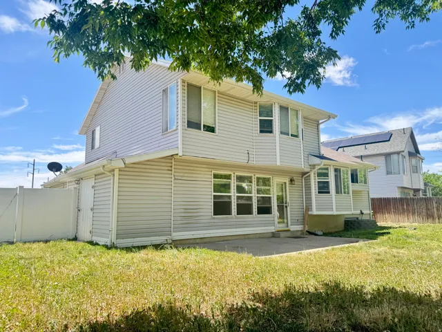 Rear exterior featuring light-colored horizontal siding and multiple windows