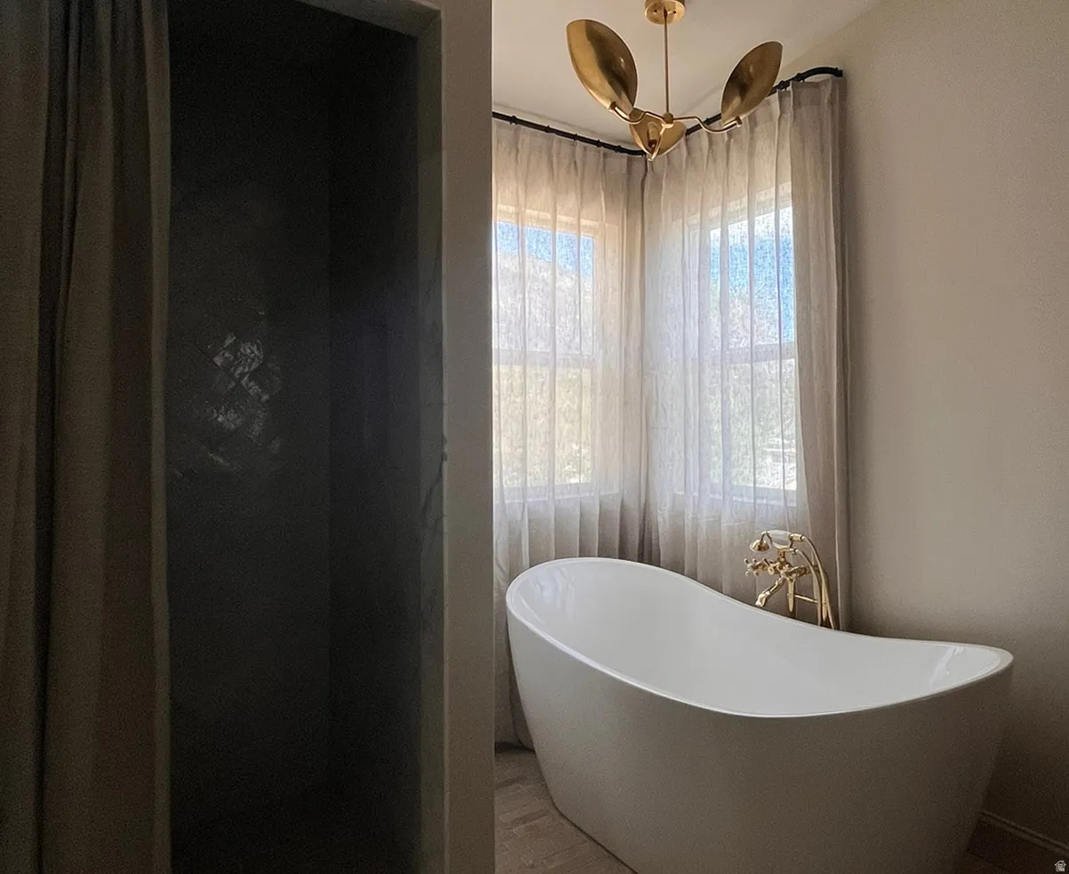 Freestanding soaking tub with floor-mounted brass fixture