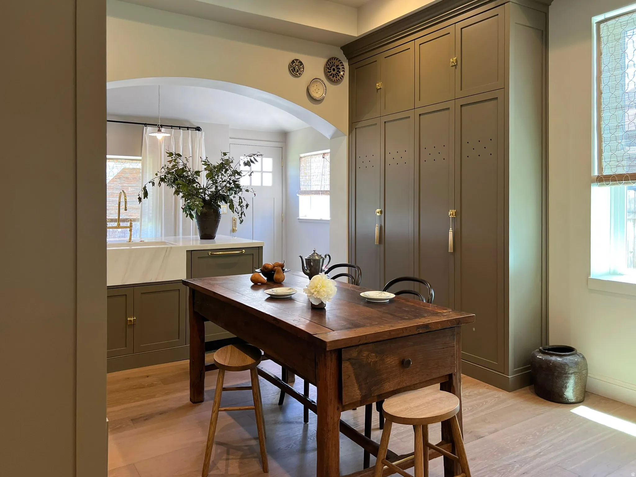 Expansive floor-to-ceiling cabinetry with crown molding and brass hardware