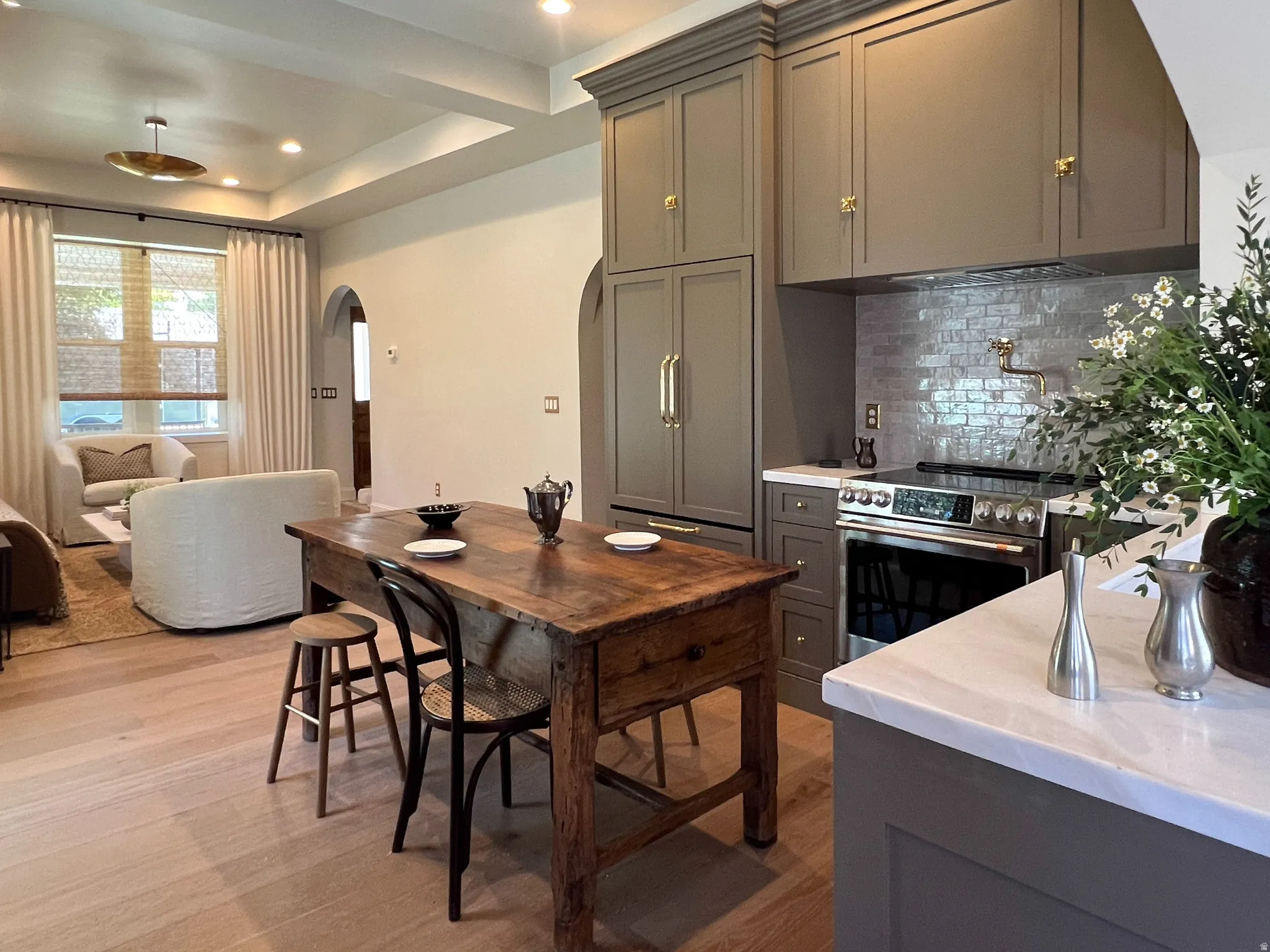 Kitchen featuring floor-to-ceiling cabinetry with crown molding, stainless steel range, and a pot filler faucet