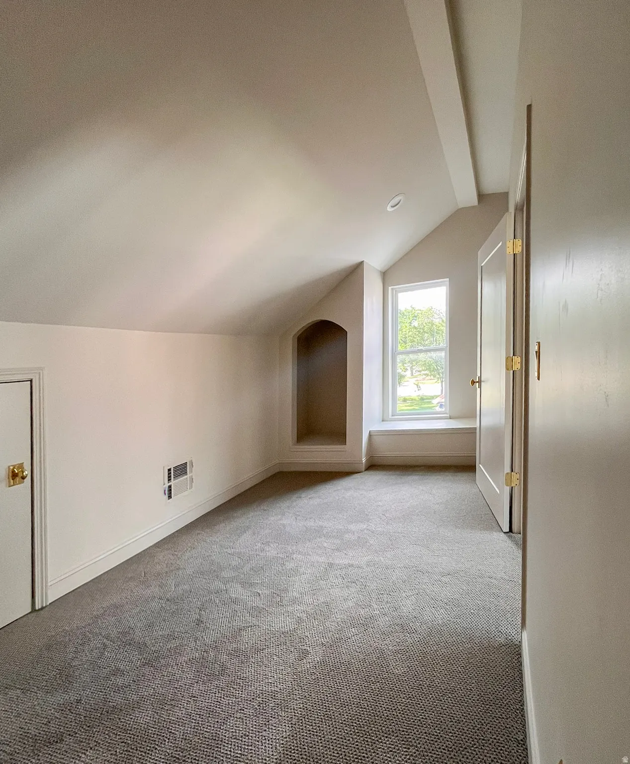Attic space featuring sloped ceilings, recessed lighting, and soft gray carpeting