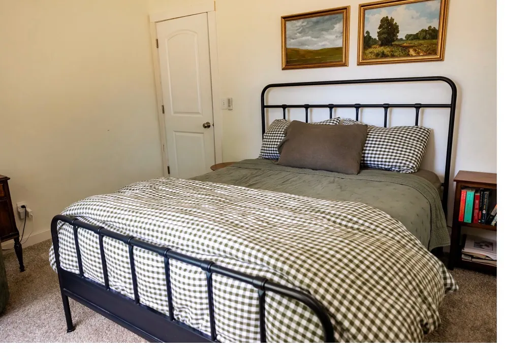 Neutral wall paint complements carpeting in this room featuring a white paneled door