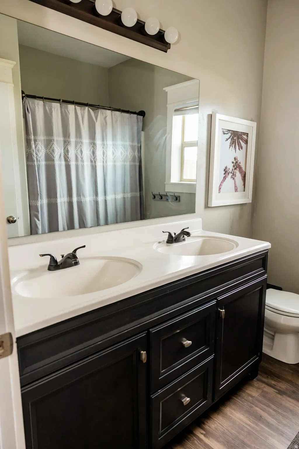 Dual sink vanity with dark cabinetry, white countertop, and oil-rubbed bronze hardware
