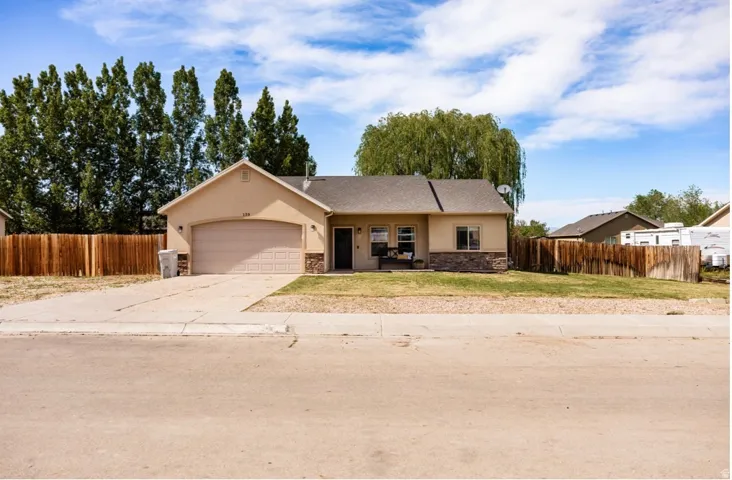 Single-story stucco exterior with stone veneer accents, attached garage, and a gabled roof