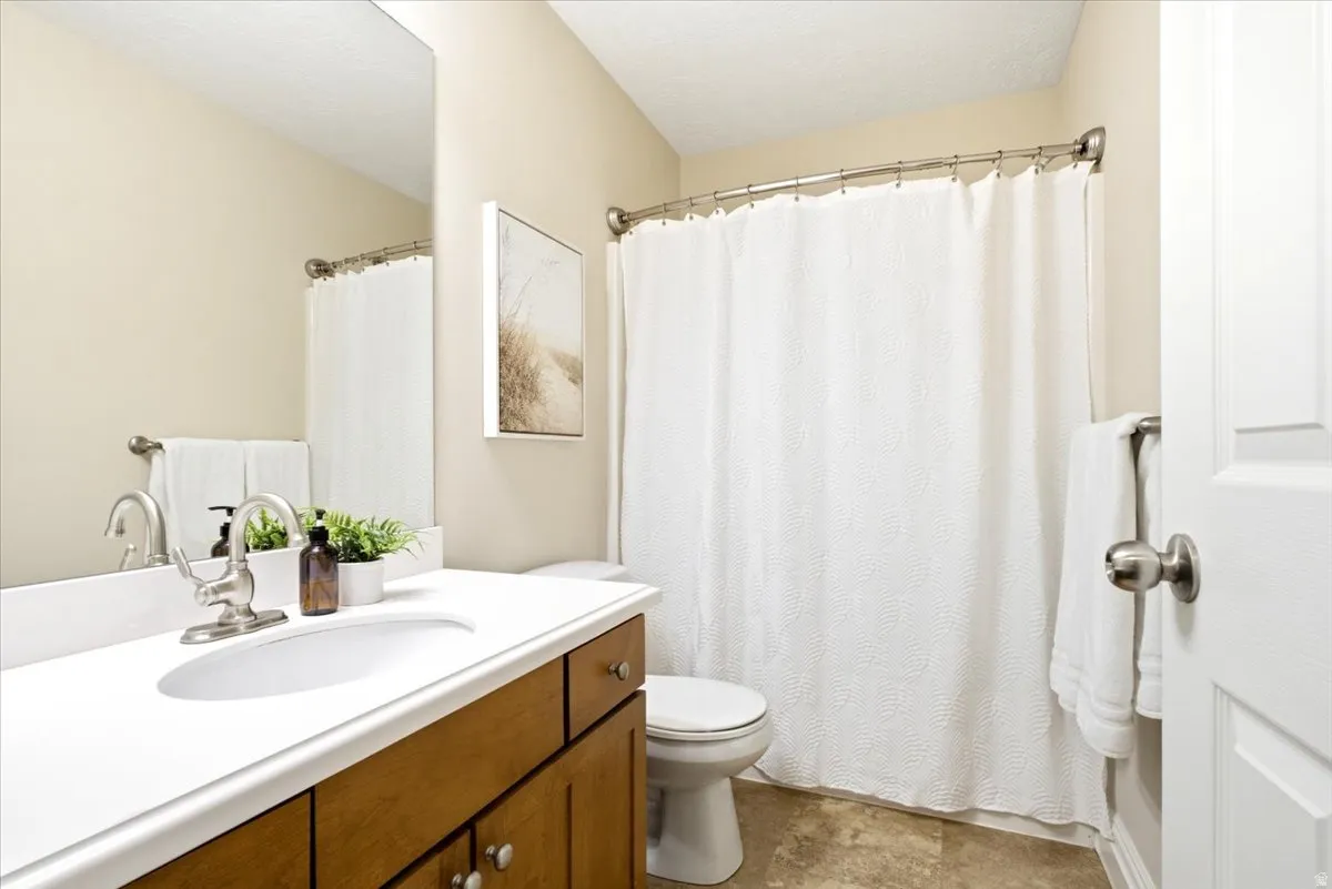 Bathroom featuring wood-finish vanity with white countertop and integrated sink