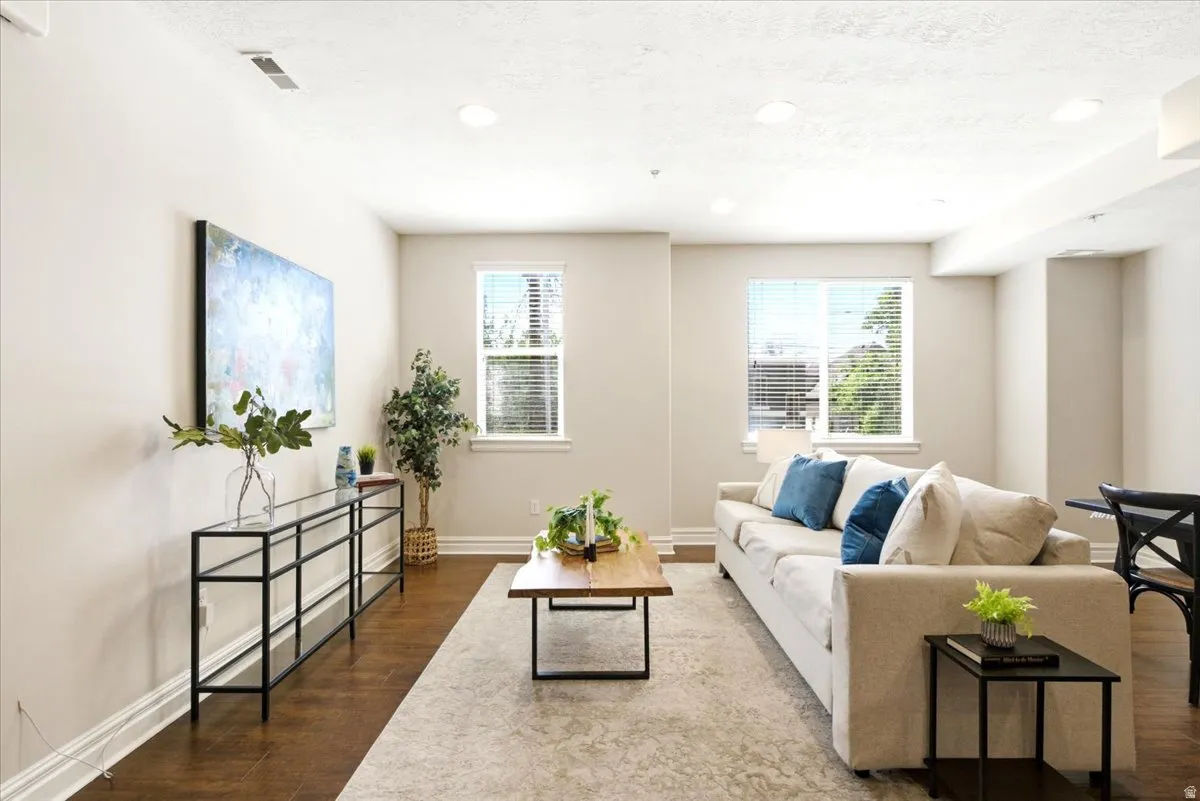 Spacious living area featuring wood-finish flooring, recessed lighting, and crown molding