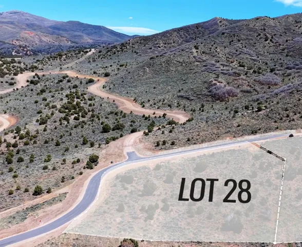 Mountain terrain featuring a paved road, natural vegetation, and a distinct property outline