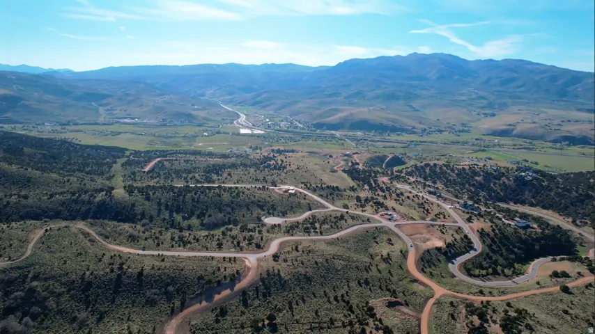 Expansive aerial perspective showcasing mountainous terrain and a winding road network