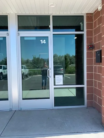 Modern commercial entrance with extensive glass paneling and a dedicated numerical address