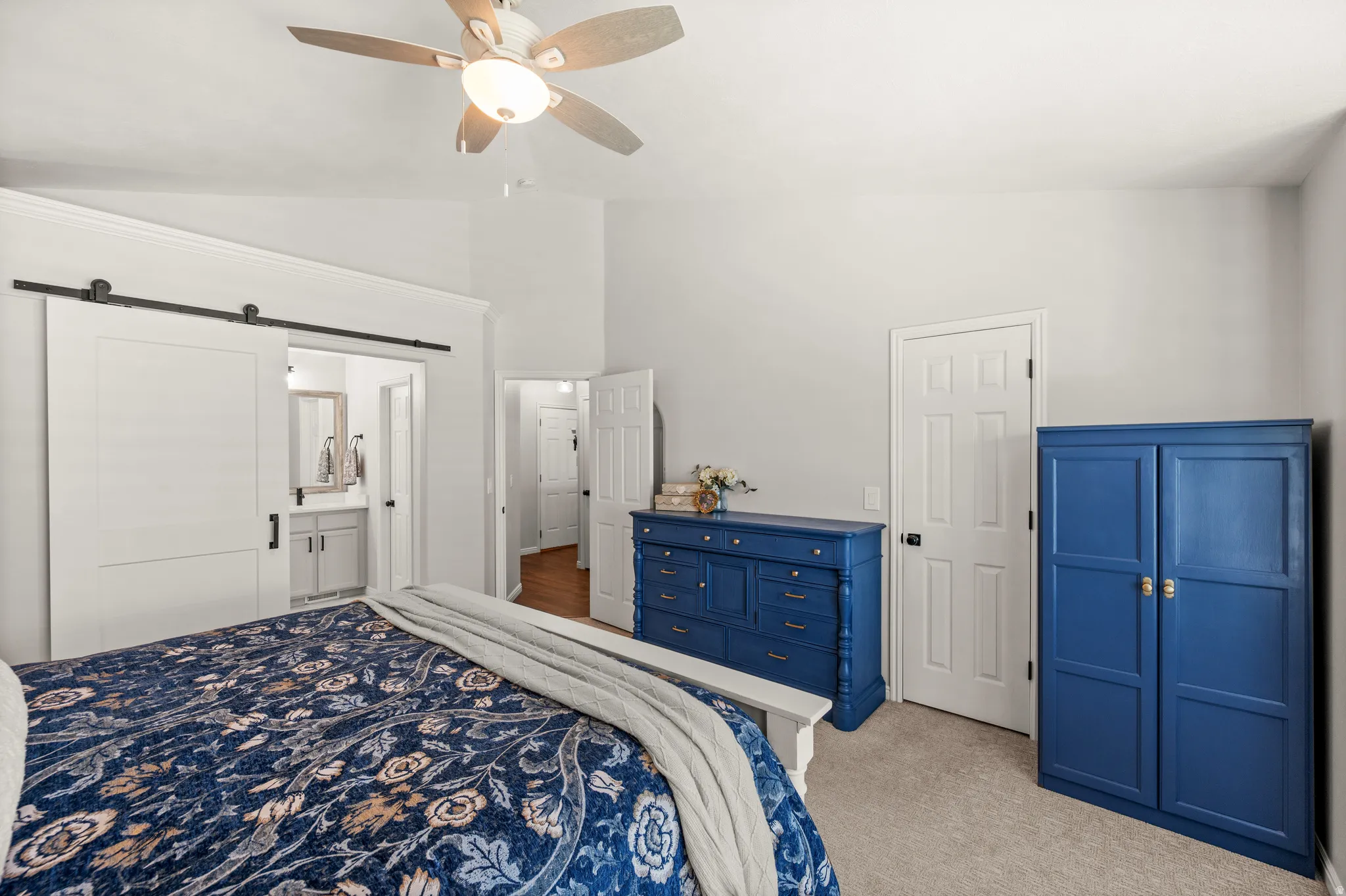 Interior room featuring vaulted ceilings, a ceiling fan with integrated lighting, and neutral carpeting