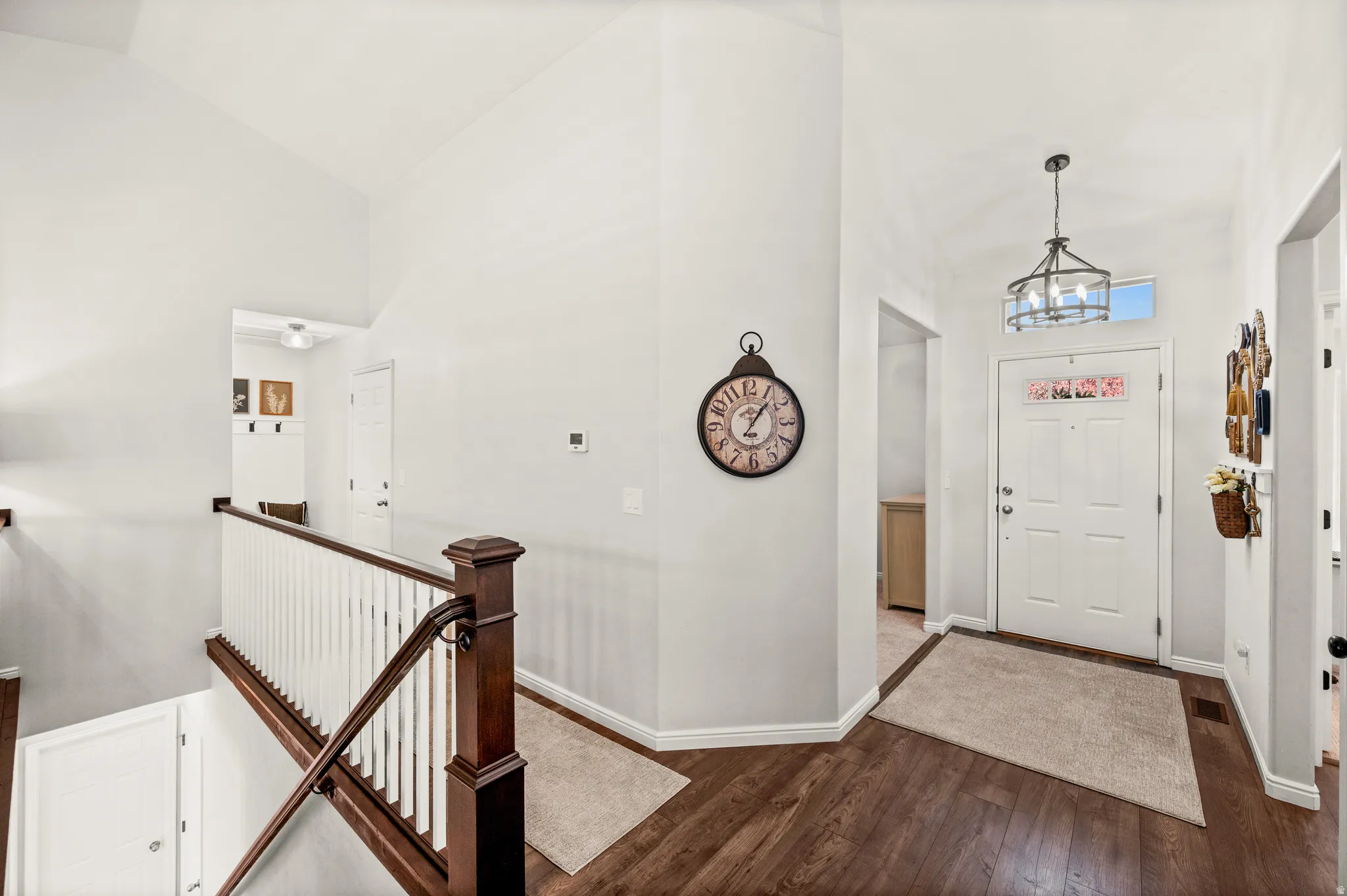Entryway featuring rich wood-finish flooring and a white paneled door with an overhead transom window