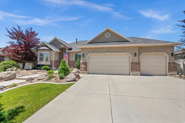 Exterior featuring a two-car garage, stucco siding, and brick accents