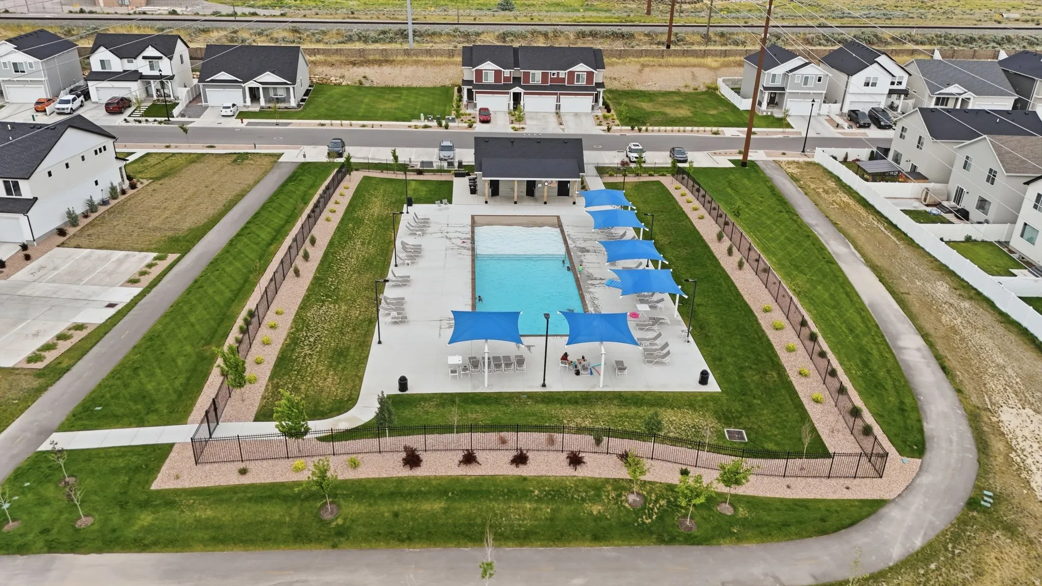 Centrally located community pool with integrated shade structures and lounge seating