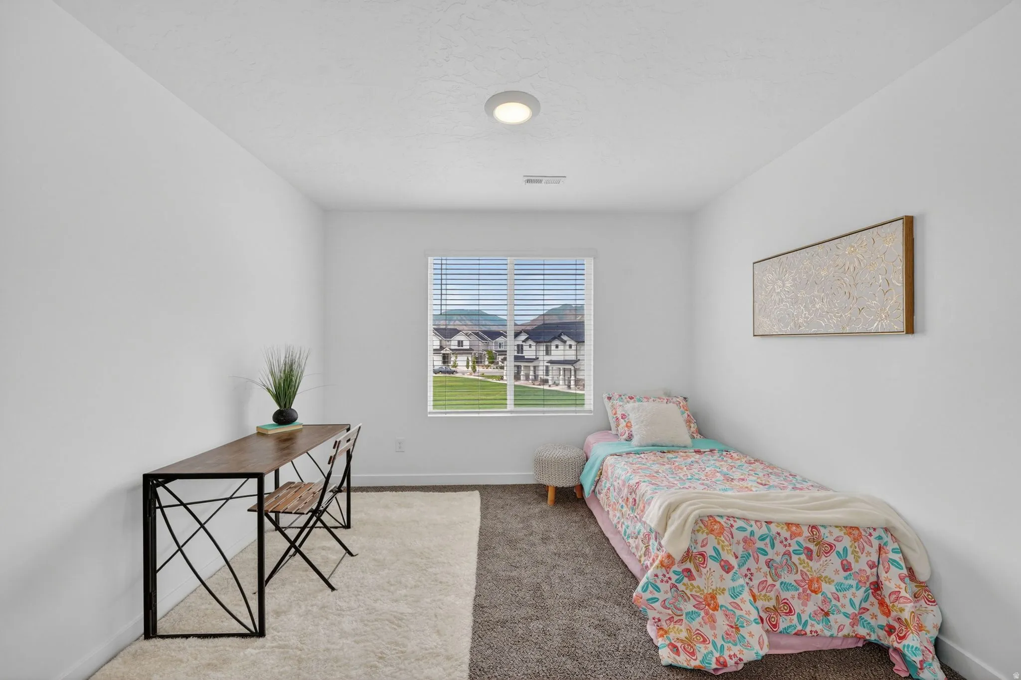 Bright room featuring a window with horizontal blinds, neutral wall paint, and a textured ceiling
