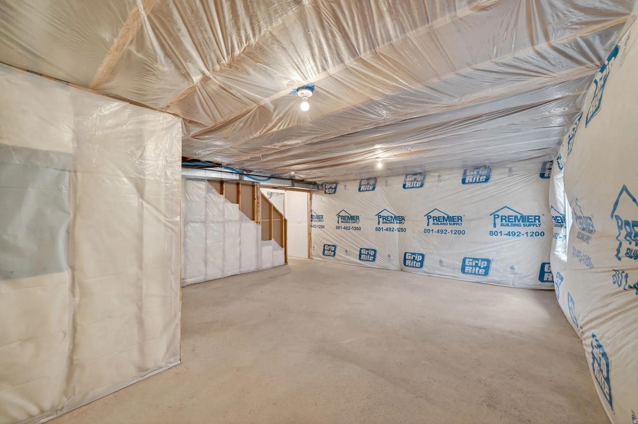 Unfinished basement featuring exposed framing, insulation, and concrete flooring
