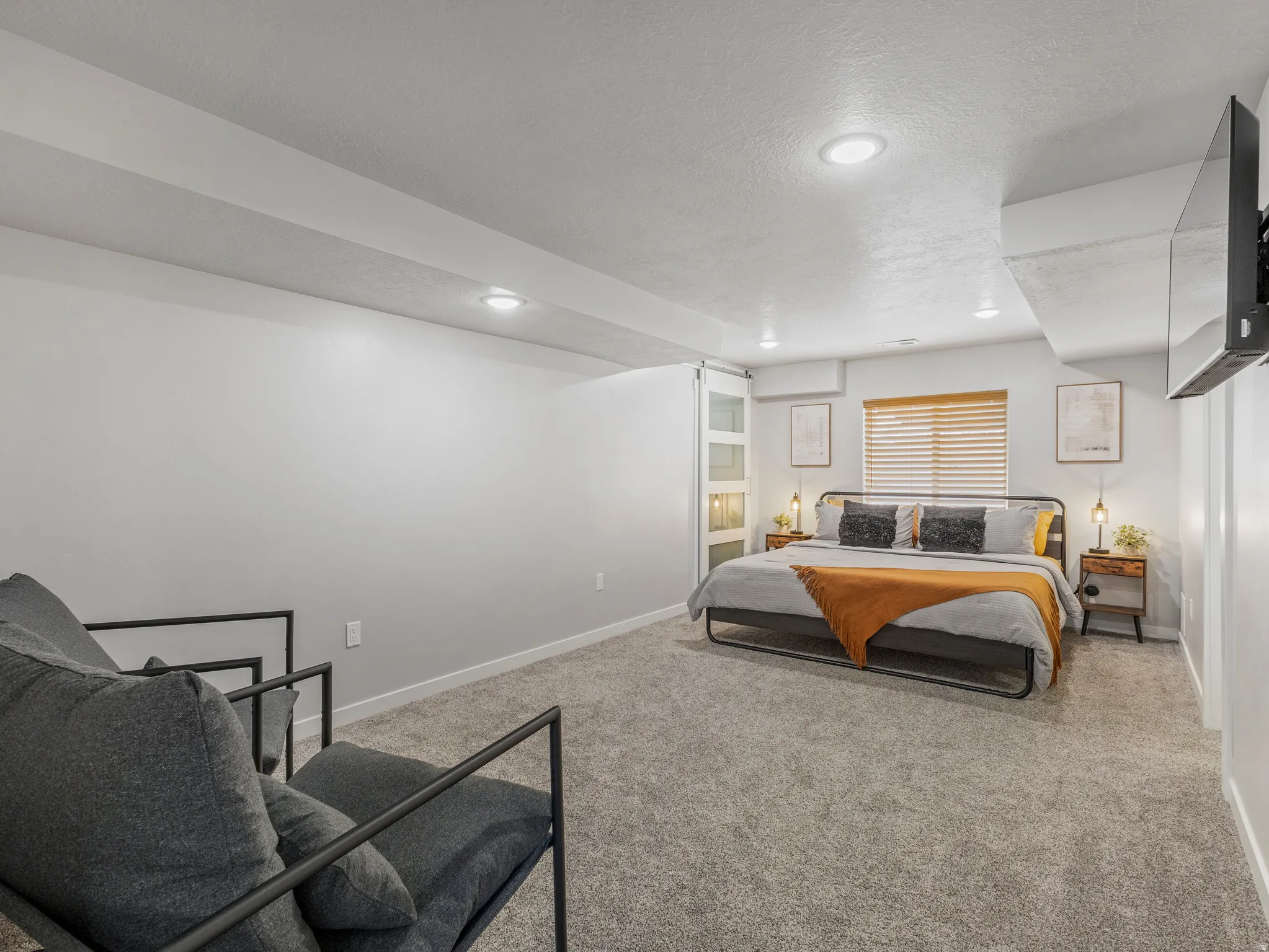 Recessed lighting illuminates this carpeted room featuring a window with horizontal blinds
