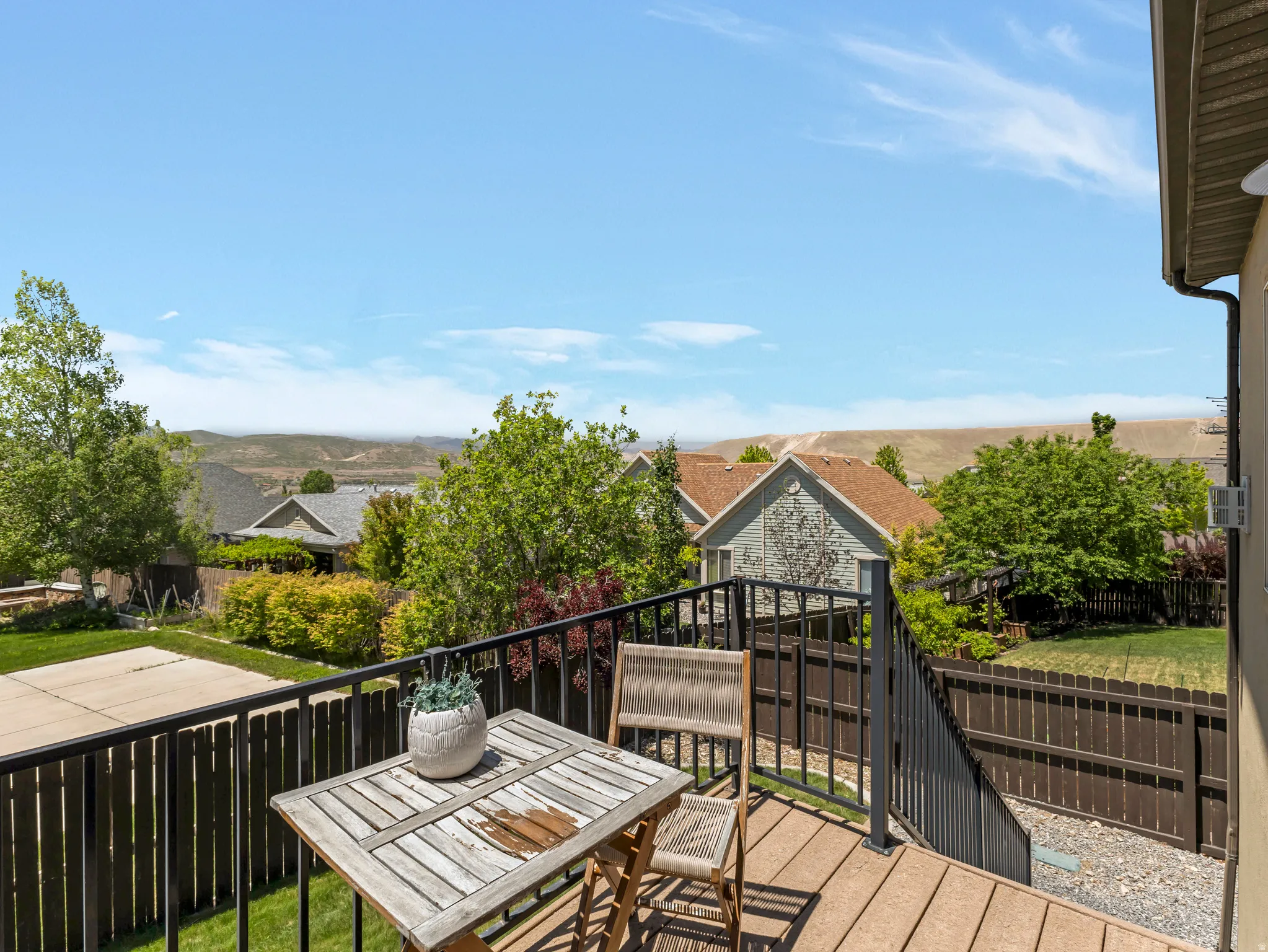 Upper-level deck featuring composite decking, black metal railings, and integrated stairs