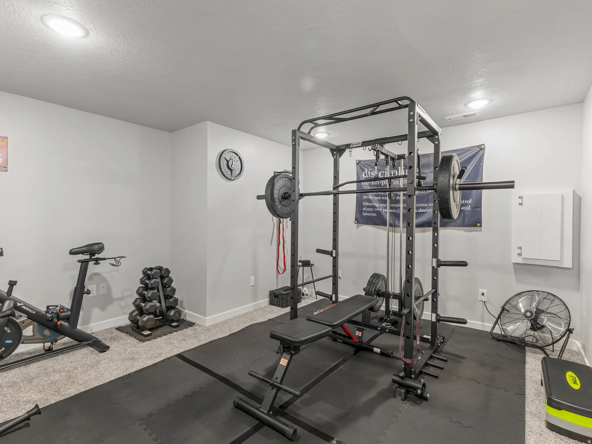 Dedicated fitness space featuring recessed lighting and light-toned walls