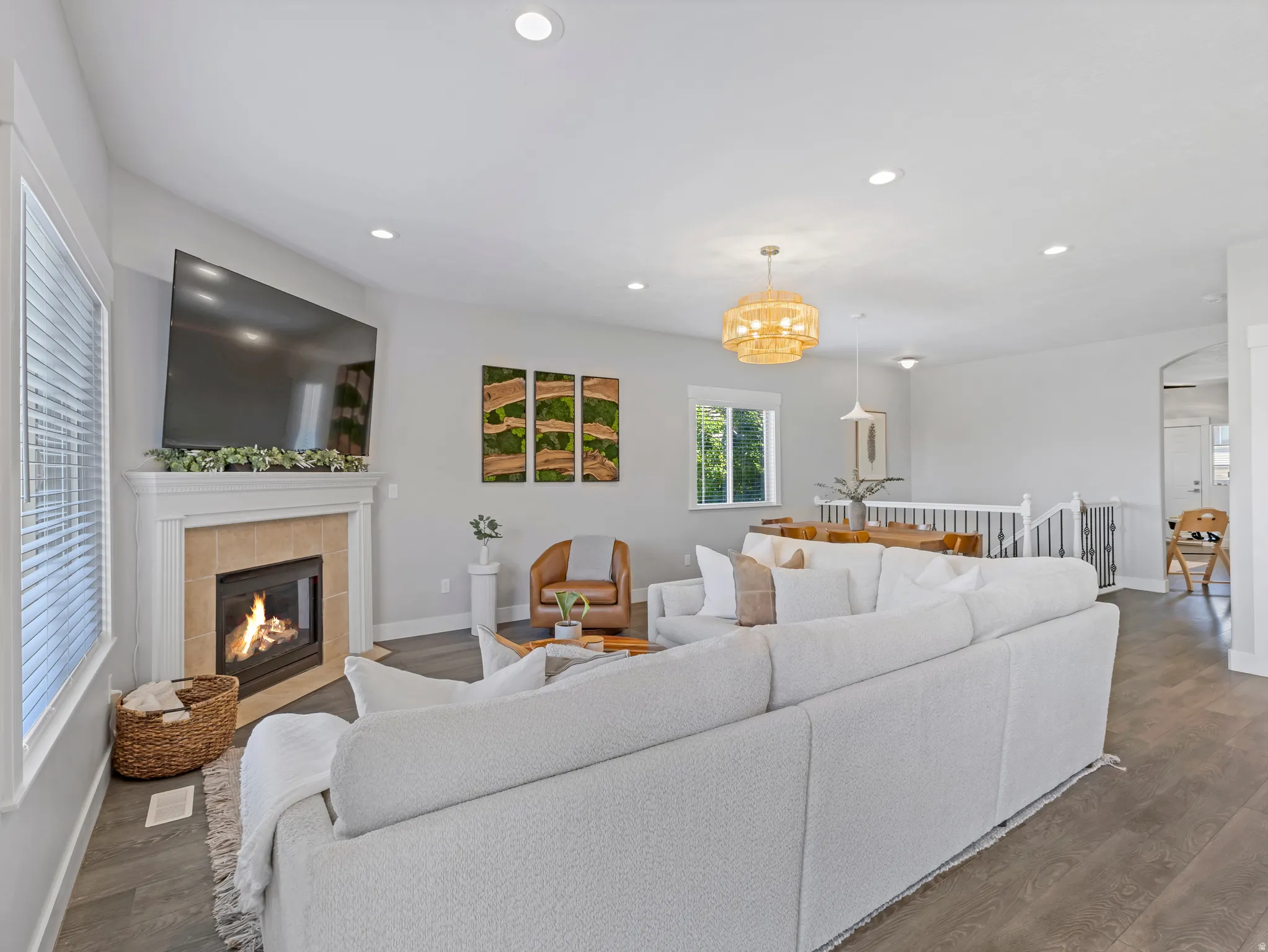 Living space featuring a tiled fireplace with a white mantel, recessed lighting, and wood-finish flooring