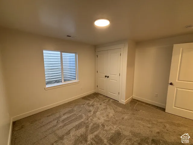 Neutral wall finishes, plush carpet flooring, functional window, and a double-door closet