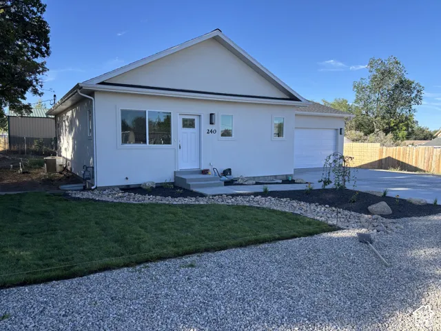 Smooth stucco exterior with a multi-pane front door, a two-car garage, and a concrete driveway