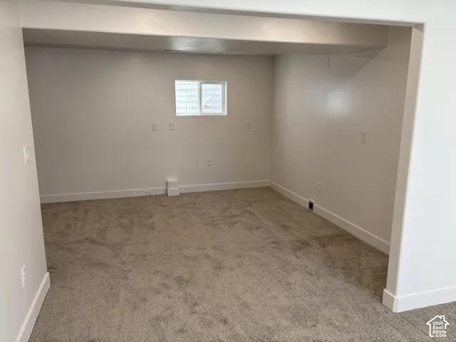 Carpeted floor, white painted walls, and a single window