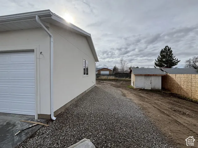 New construction exterior featuring a white garage door, light-colored stucco siding, and white gutters