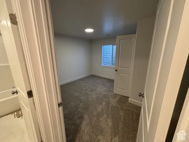 Carpeted room with recessed lighting and a window with horizontal blinds