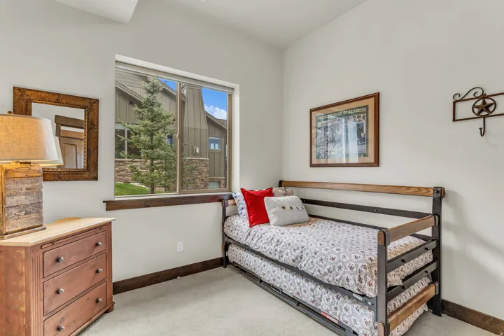 Bright interior space featuring a large window with exterior landscaping, light-toned walls, and wood-finish trim