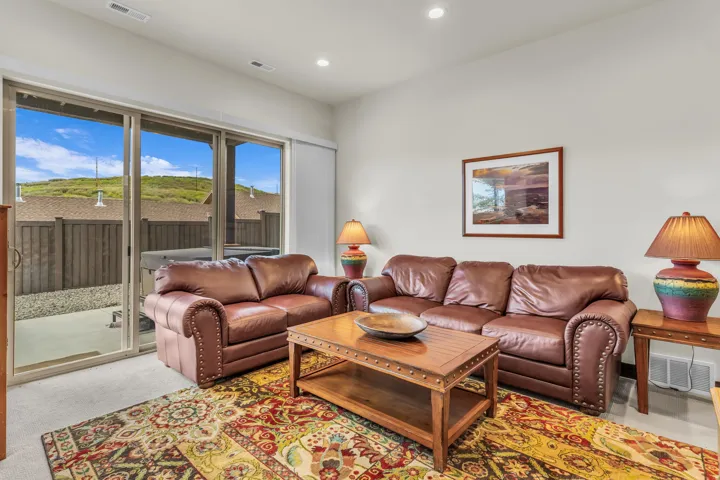 Spacious living area featuring large sliding glass doors, recessed lighting, and light-colored walls