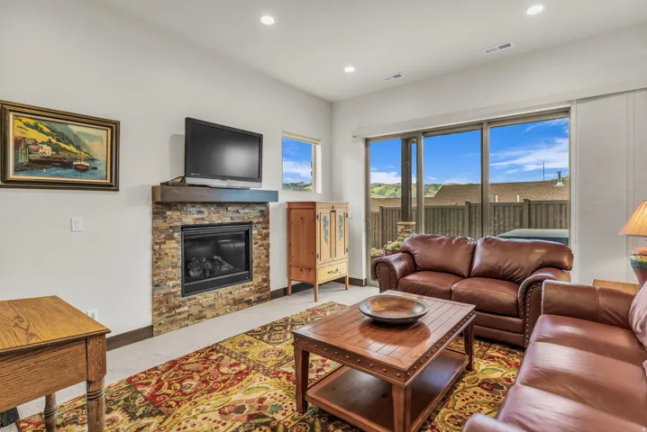 Living area with a stone-clad fireplace and a wood mantel