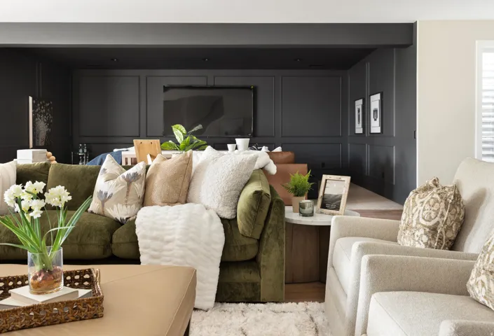 Recessed area featuring dark paneled walls, an integrated television, and overhead lighting