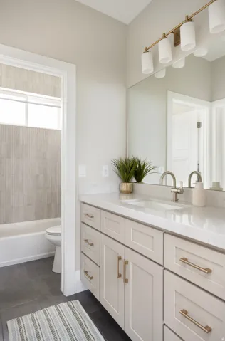 Bathroom featuring a single vanity with light cabinetry, a white countertop, and brushed nickel fixtures
