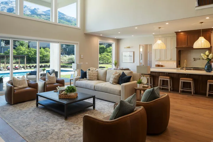 Open-concept living space featuring wood-finish flooring, a two-story ceiling, and a kitchen with an extended island