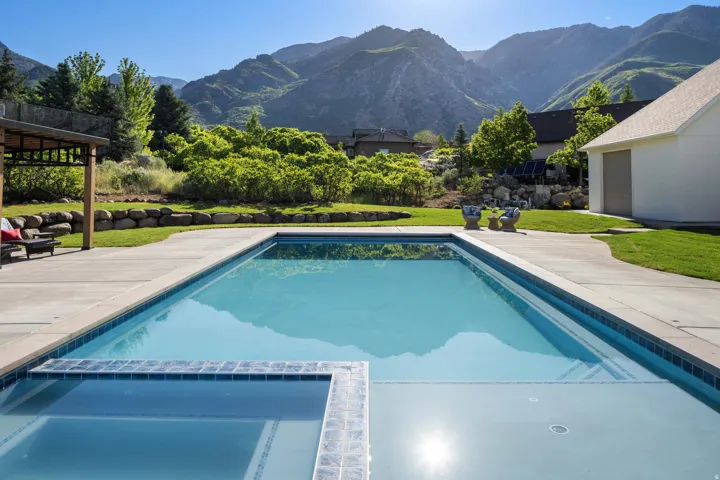 Rectangular in-ground pool with integrated spa, surrounded by expansive concrete decking
