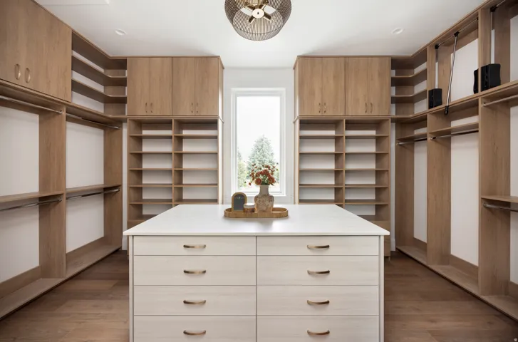 Custom closet system featuring natural wood-finish cabinetry and shelving
