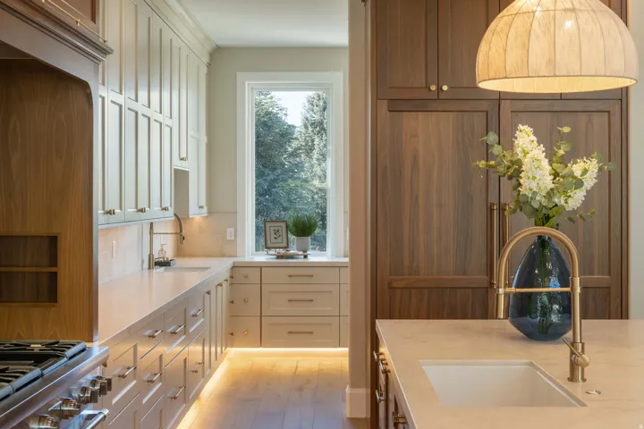 Contemporary kitchen featuring extensive cabinetry, under-cabinet lighting, a large window, and wood-finish flooring