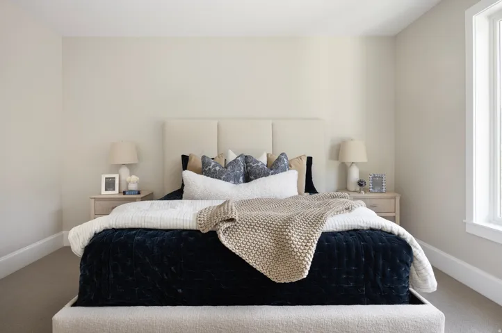 Carpeted bedroom featuring an upholstered bed frame with a paneled headboard