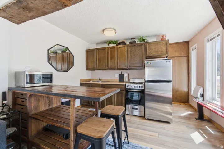 Compact kitchen featuring wood-finish flooring and upper cabinetry