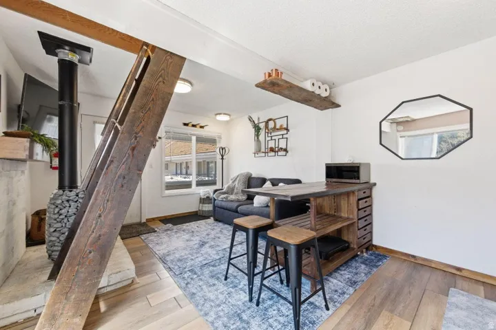 Living area featuring a wood-finish flooring, white walls, and recessed lighting