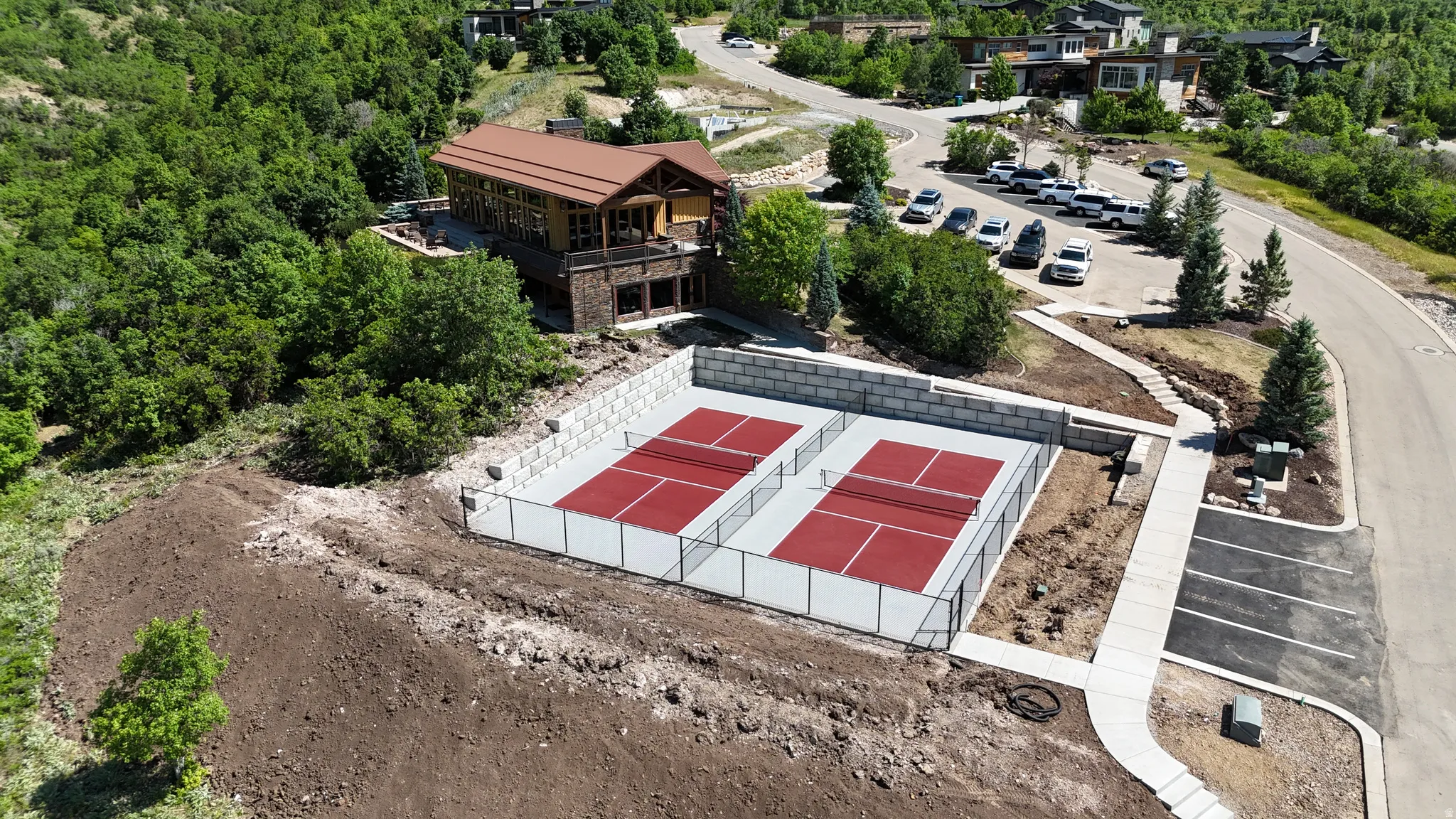 Two red hard-surface courts with white perimeter fencing