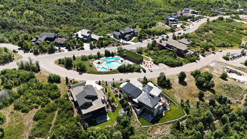 Aerial perspective showcasing multiple properties nestled within a verdant, hilly landscape