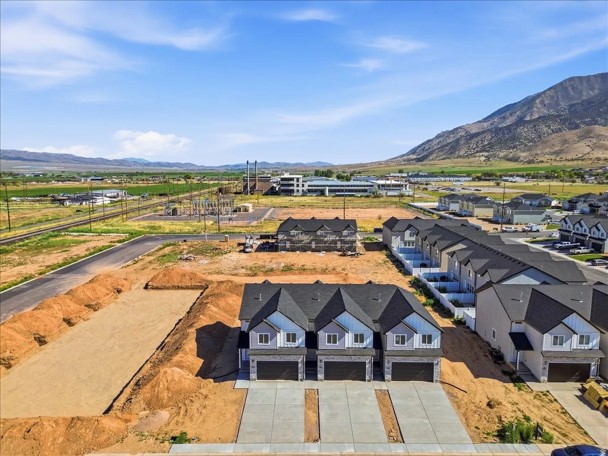 New construction townhome development featuring light-toned siding and dark shingle roofing