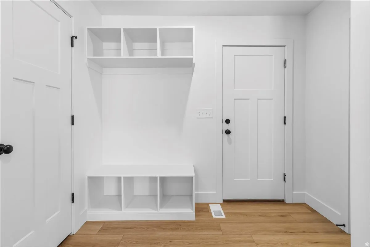 Built-in entryway organization featuring open shelving and bench seating with cubby storage