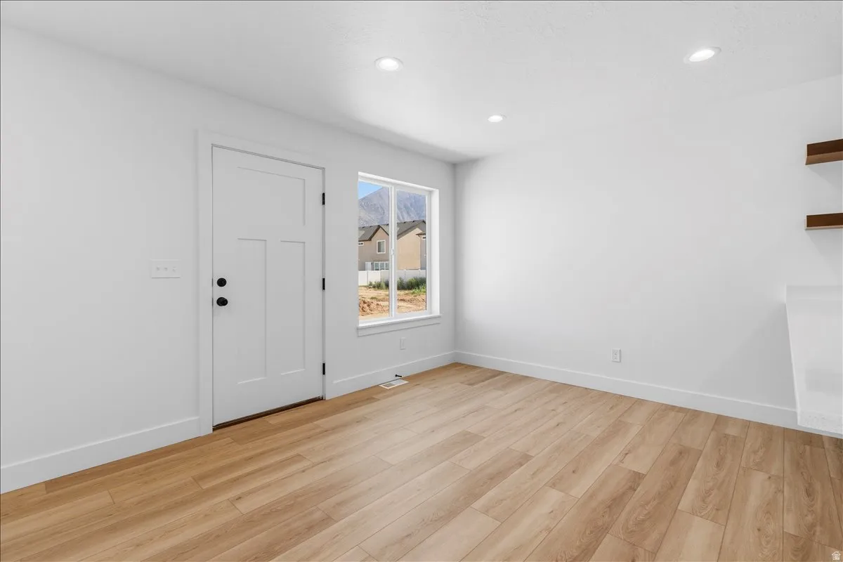 Bright interior space featuring wood-finish flooring and recessed lighting
