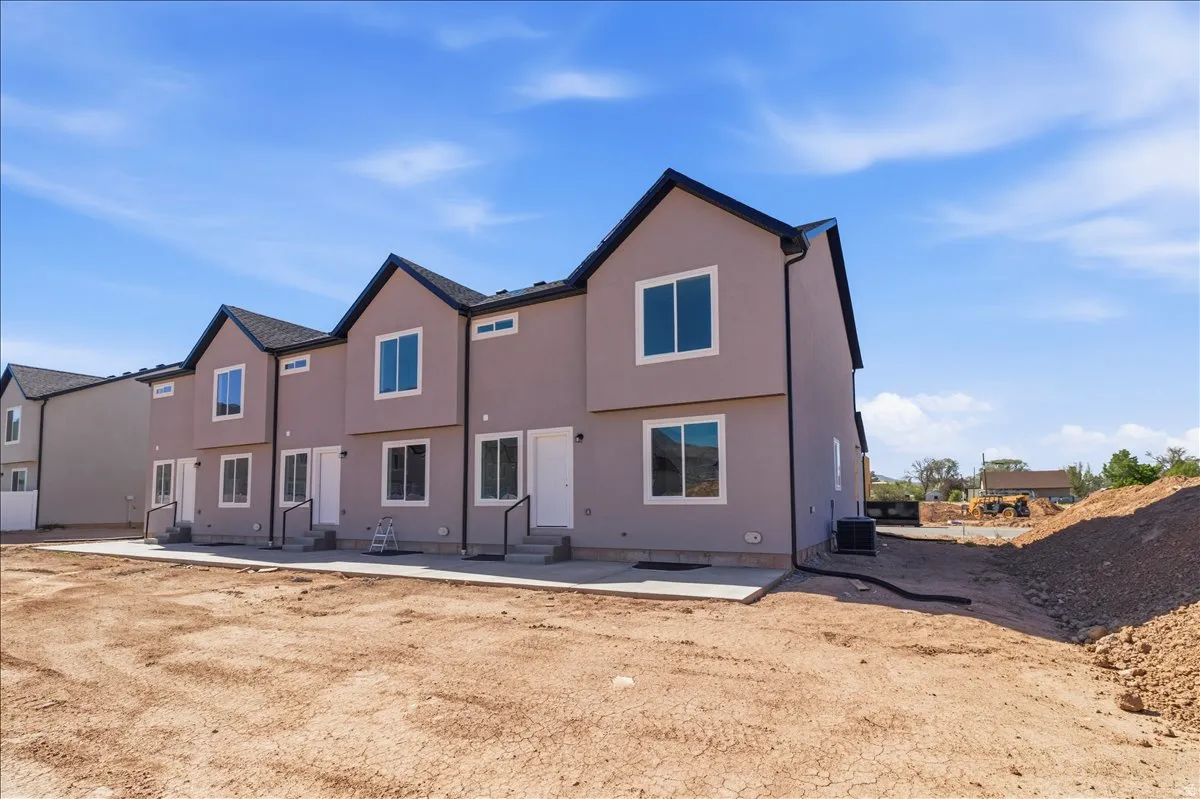 Contemporary townhome exterior featuring a neutral stucco finish and contrasting dark trim
