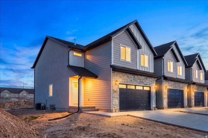 Modern exterior featuring horizontal siding, stone veneer accents, and a dark garage door