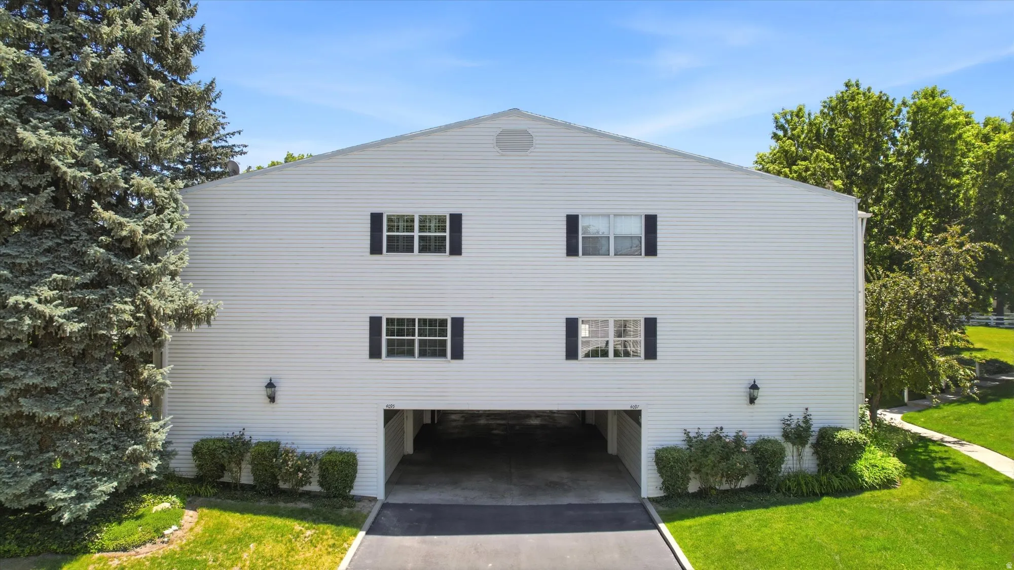 White siding exterior with black window shutters and two levels of windows