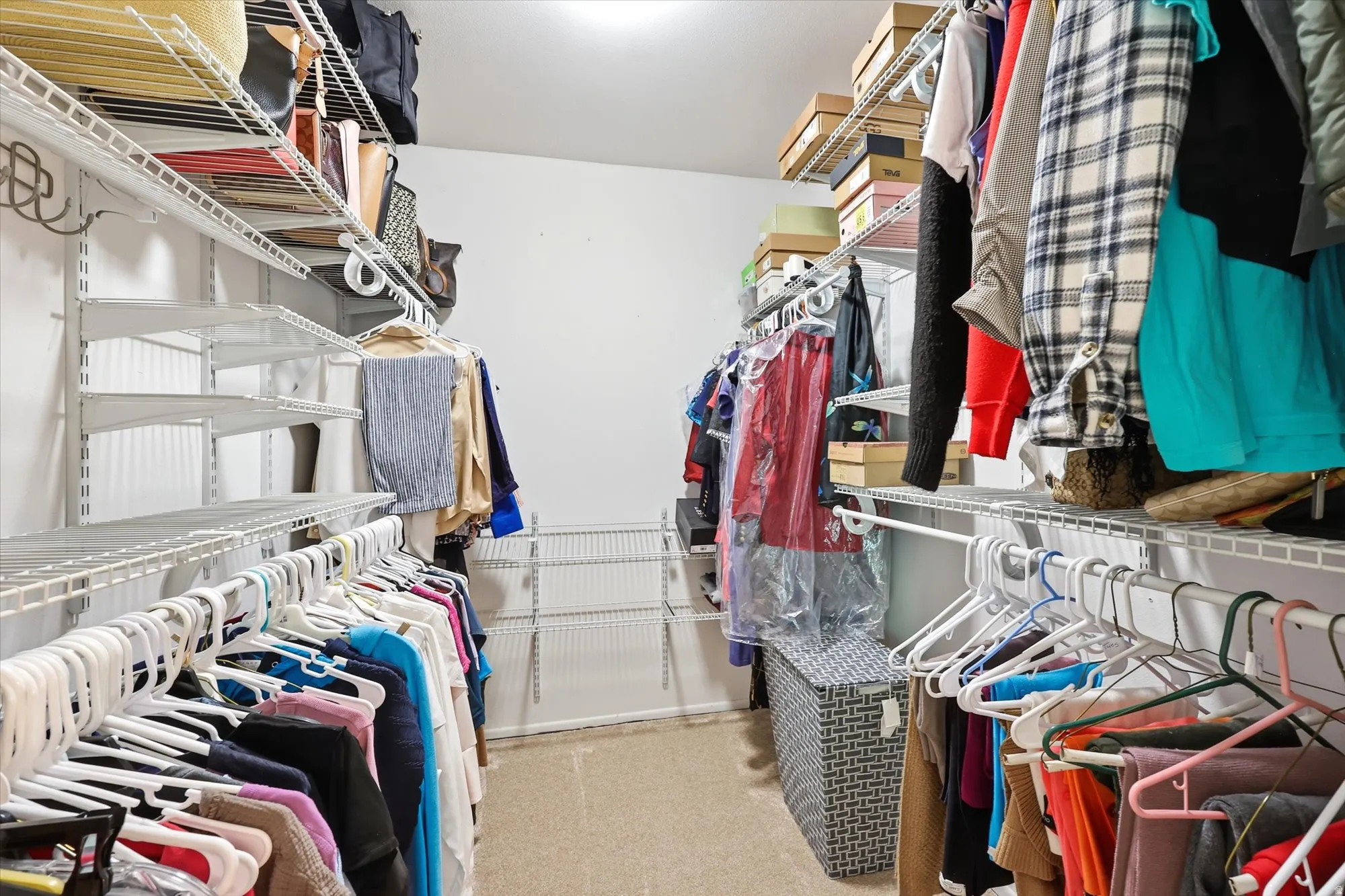 Walk-in closet featuring built-in wire shelving and hanging rods