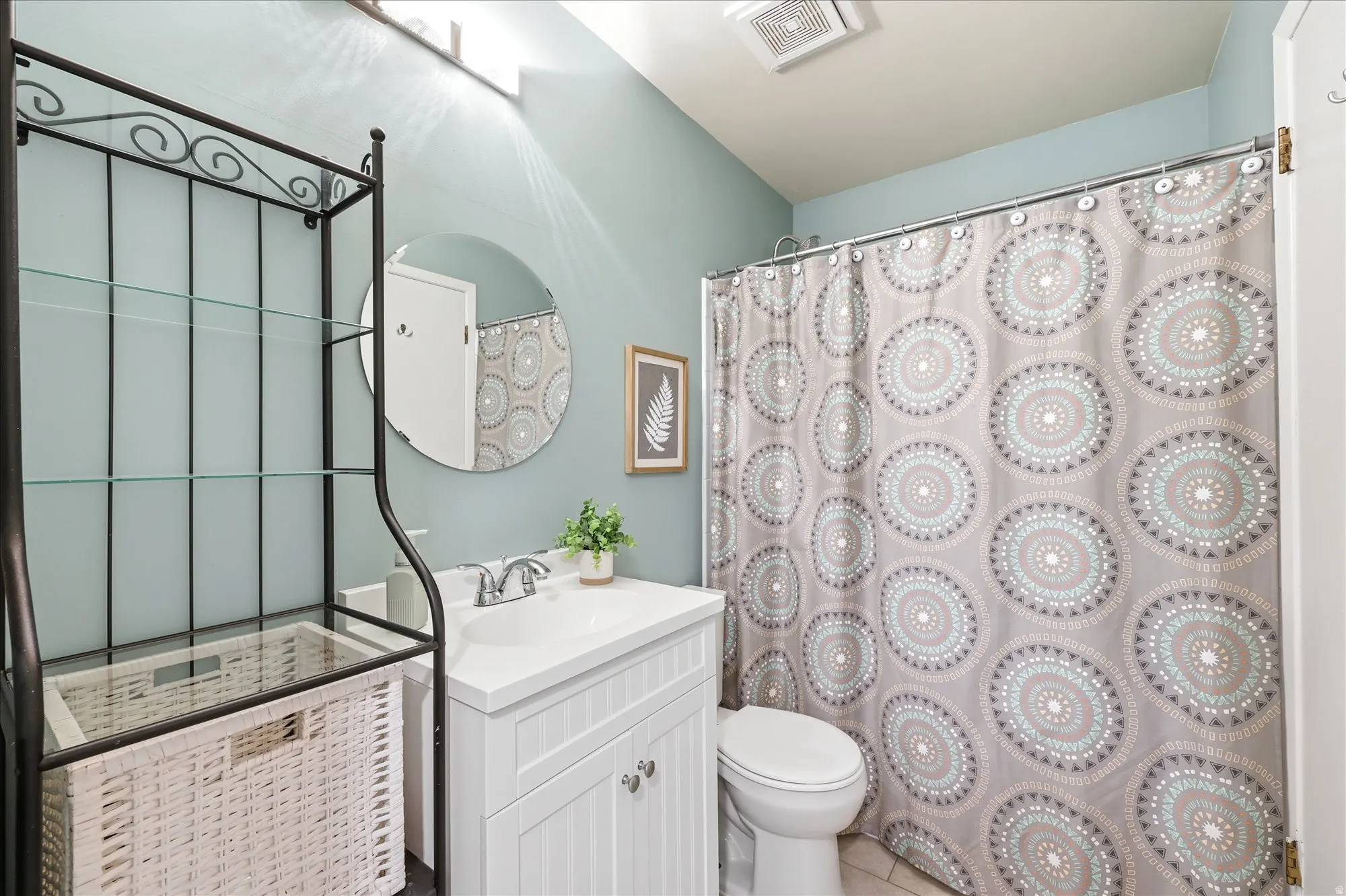 Full bathroom featuring a white vanity with integrated sink, coordinating toilet, and a shower-over-tub combination